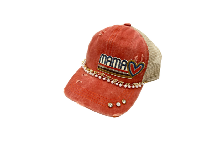 Orange  criss cross ponytail trucker with a retro multi colored embroidered patch, double trucker chain and with three crystal rivets on the bill.